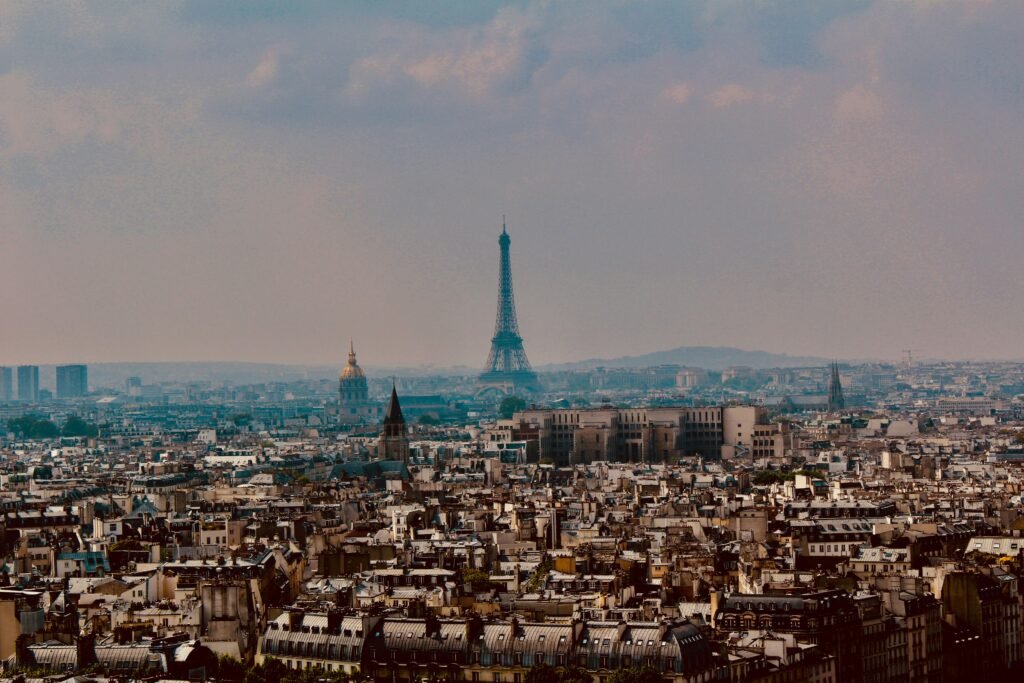 Explore the stunning panoramic cityscape of Paris with the iconic Eiffel Tower rising above the urban landscape.